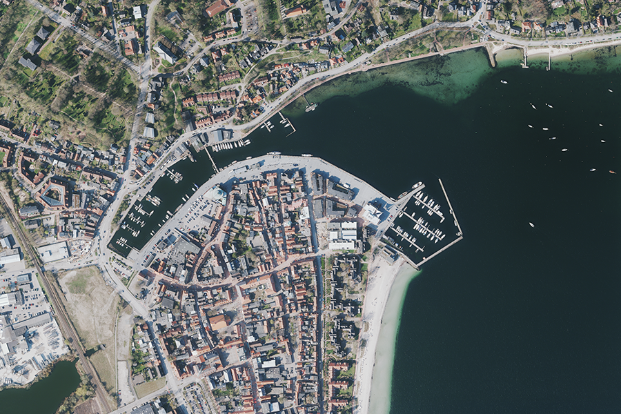 Luftbildaufnahme des Hafens von Eckernförde mit Anlegestellen und Uferbereich